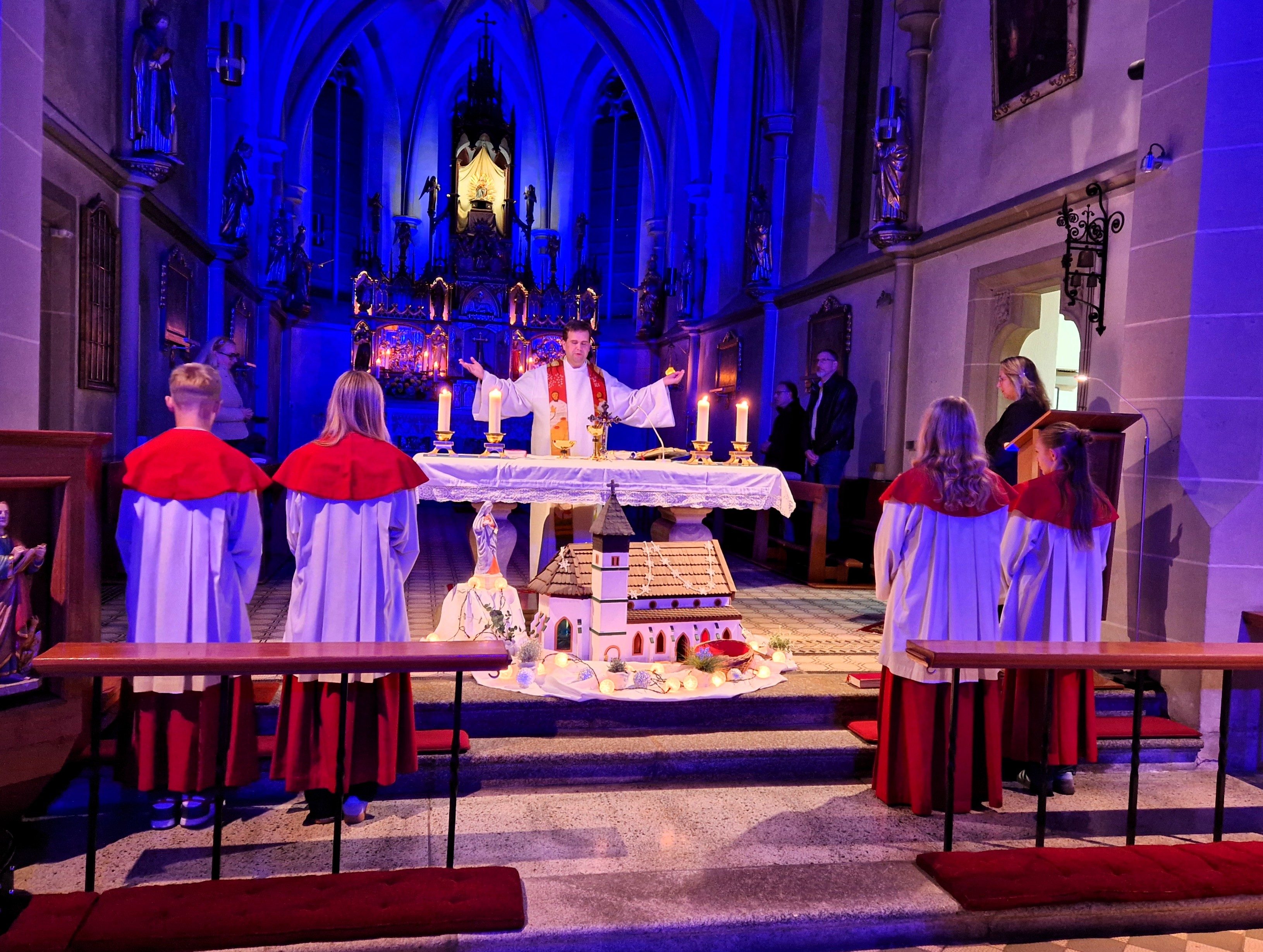 Hell leuchtet das Gnadenbild vom blau beleuchteten Hochaltar, Dekan Detlef Pötzl zelebriert den Gottesdienst (Foto: Susanne Deuerling)