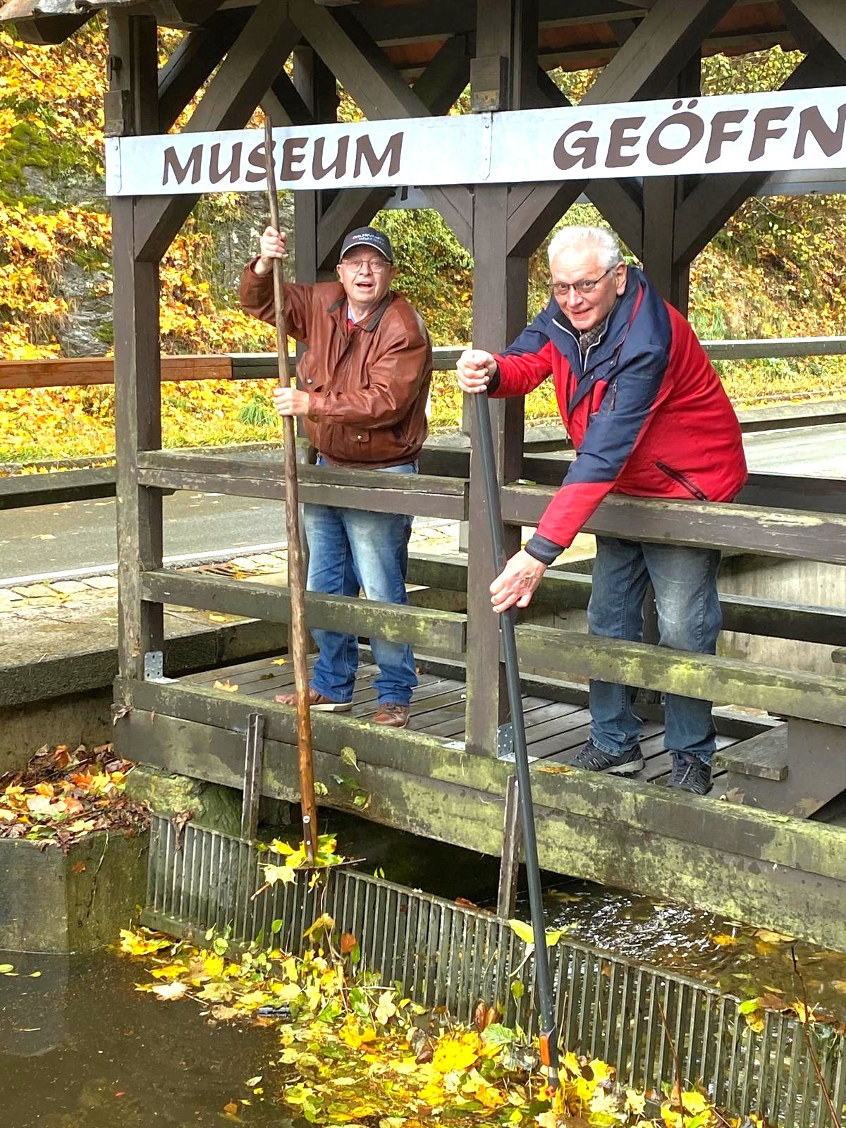 Bruno Beierlorzer (re) und Rolf Menke säubern den eisernen Rechen, der das Mühlrad vor Treibgut schützt. (Foto: Bernhardt Lang/S. Deuerling)