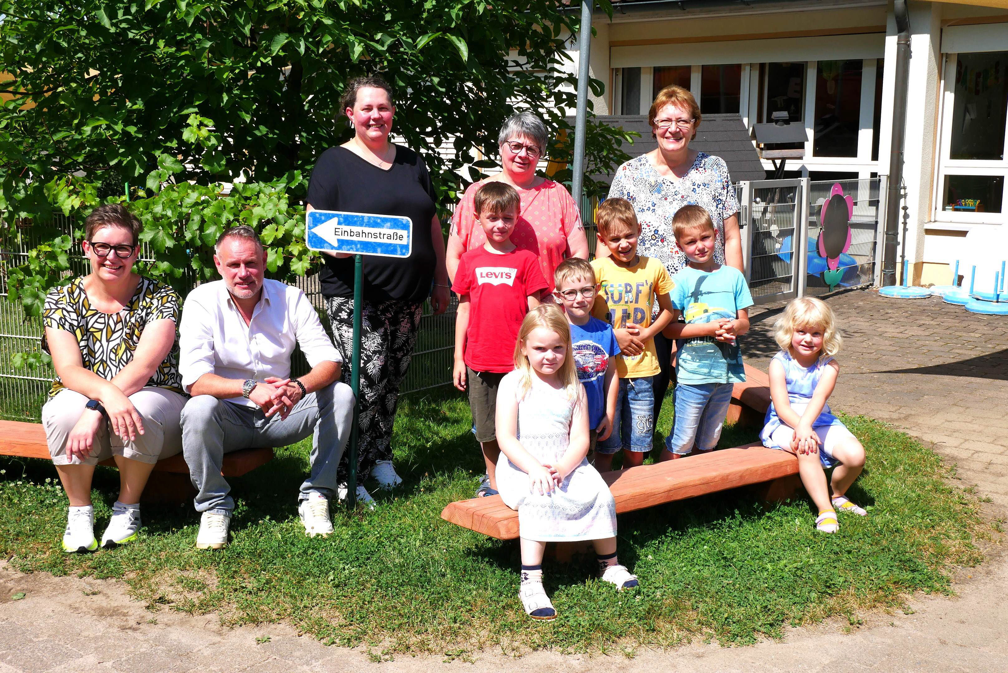 Kleine Sitzbänke für den Garten wurden im Sommer 2024 vom Kindergartenförderverein angeschafft. Kathrin Gremer-Schneider (3.v.li) und die Kindergartenleitung sowie der neue Geschäftsführer Frank Hauck (2.v.li) freuen sich zusammen mit den Kindern.